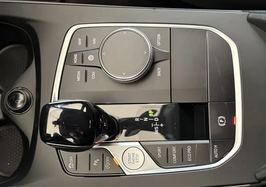 Vue rapprochée de la console centrale noire de la BMW Série 1 116i, avec levier de vitesses automatique et commandes multifonctions.