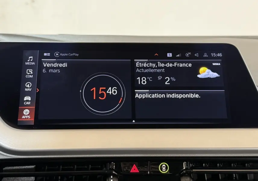 Écran tactile central de la BMW Série 1 116i Business Design affichant l'heure et la météo, intérieur beige.