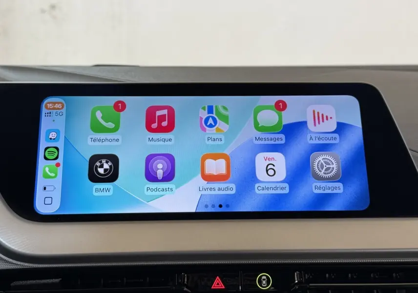 Écran tactile central de la BMW Série 1 116i Business Design 2023 affichant Apple CarPlay en intérieur beige.