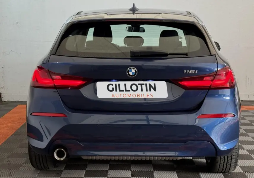 Vue arrière d'une BMW Série 1 116i bleu avec feu LED et sortie d'échappement visible côté gauche.