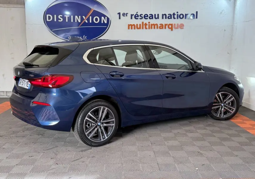BMW Série 1 116i Business Design bleu vue de profil droit, avec jantes alliage et feux arrière LED distinctifs.