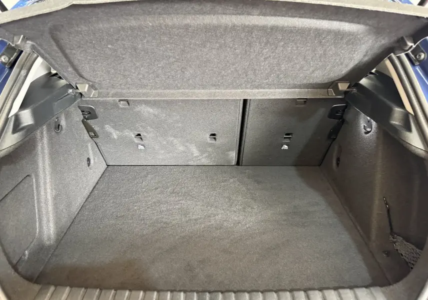 Vue intérieure du coffre spacieux et tapissé en gris foncé d'une BMW Série 1 116i Business Design 2023.