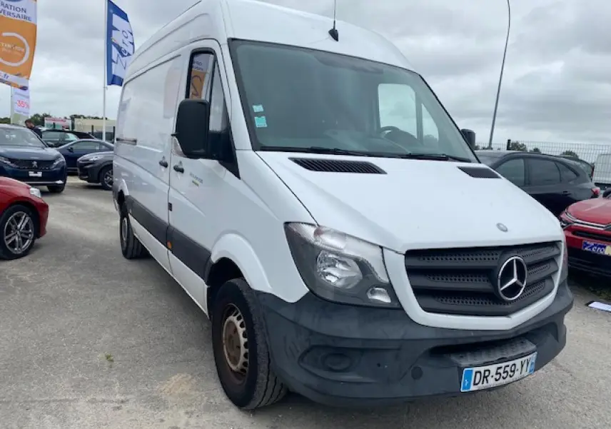 Fourgon Mercedes Sprinter blanc en 3/4 avant droit, avec calandre noire et pare-chocs avant foncé visible.