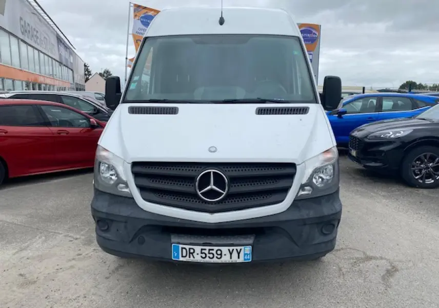 Vue frontale d'un Mercedes Sprinter fourgon blanc de 2015 avec calandre noire et pare-chocs gris.