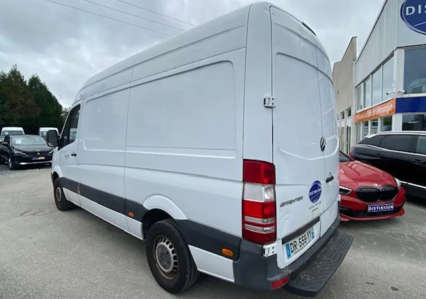 Vue 3/4 arrière droite d’un fourgon Mercedes Sprinter blanc de 2015, avec porte arrière fermée et pare-chocs noir.