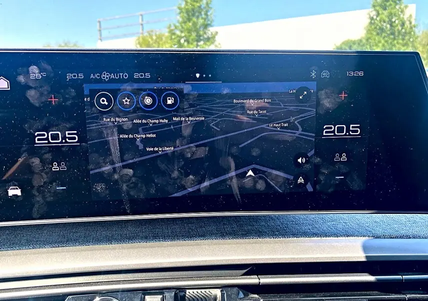 Écran tactile central affichant la navigation et la climatisation dans le Peugeot 5008 Hybrid 145 allure gris Artense.