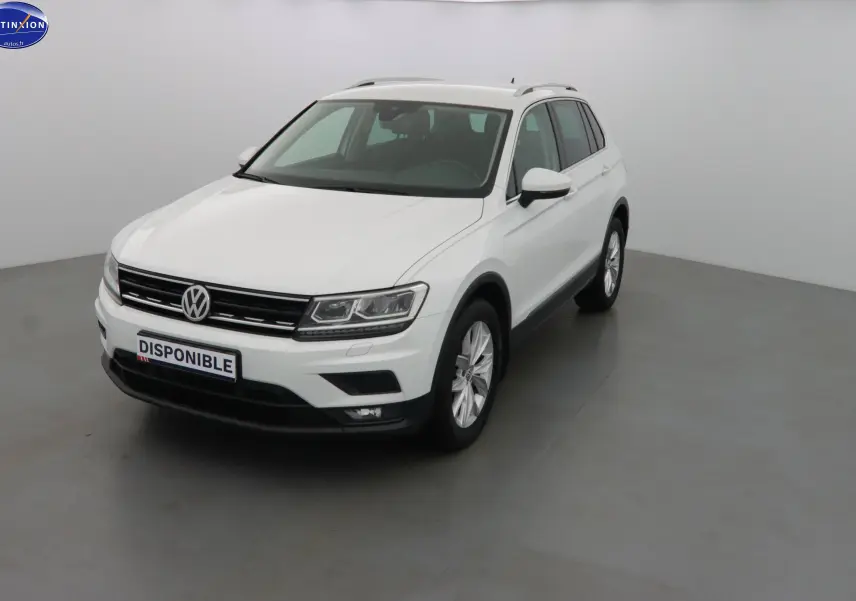Volkswagen Tiguan blanc en 3/4 avant droit, avec calandre noire et jantes alliage visibles.