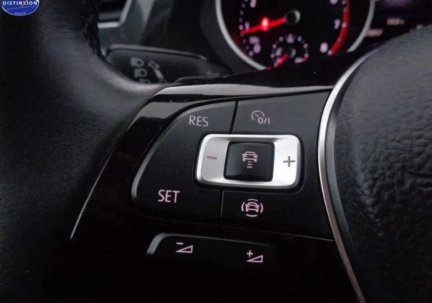 Gros plan sur les commandes au volant du Volkswagen Tiguan 2019, avec boutons de régulateur de vitesse et affichage du tableau de bord.