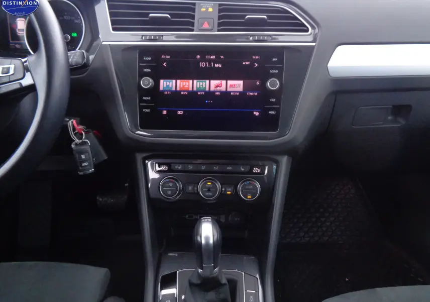 Vue intérieure du tableau de bord du Volkswagen Tiguan blanc 2019, avec écran tactile et commandes de climatisation visibles.