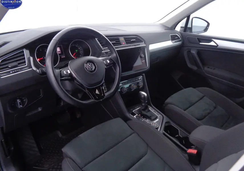 Intérieur noir du Volkswagen Tiguan 2019 vu côté conducteur, avec tableau de bord moderne et volant multifonction.