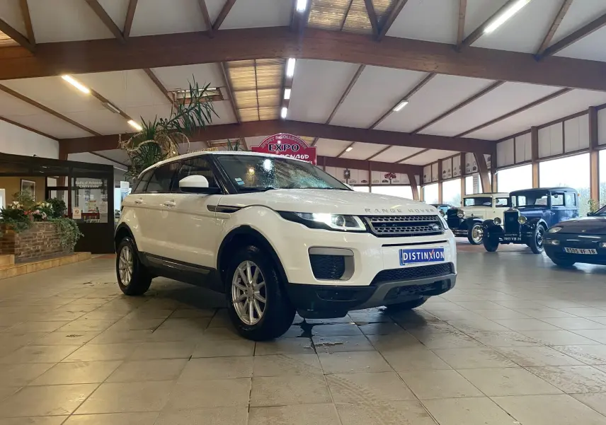 Vue 3/4 avant d'un Range Rover Evoque blanc 2016 exposé en intérieur avec plaques Distinxion.