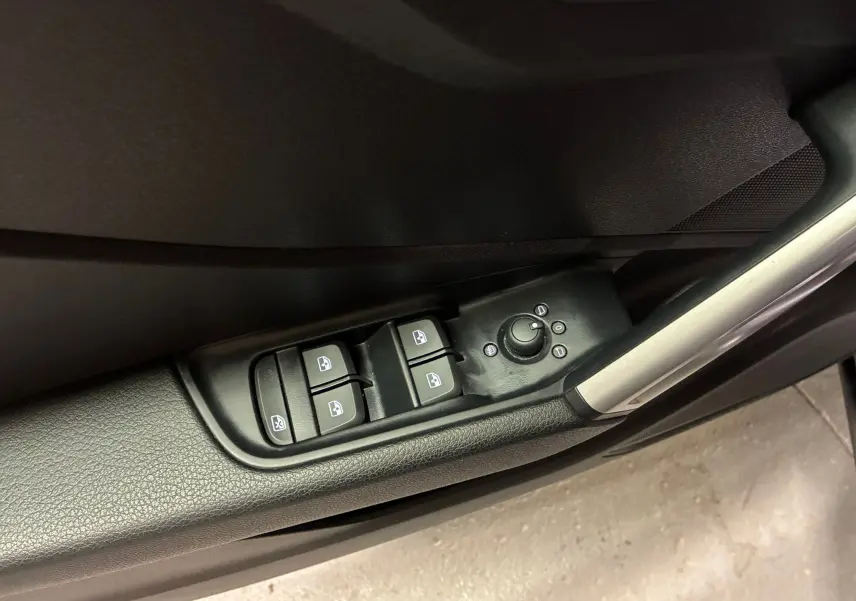 Gros plan sur les commandes des vitres et des rétroviseurs côté gauche intérieur noir de l'Audi Q2 2023 S-Line.