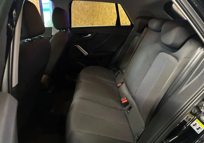Vue latérale droite de l'habitacle arrière noir de l'Audi Q2 35 TFSI S-Line 2023 avec sièges tissu et appuie-têtes.