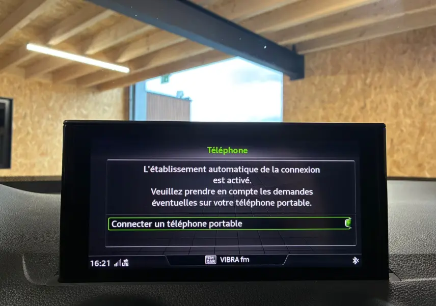 Écran central de l'Audi Q2 35 TFSI S-Line 2023 affichant la connexion automatique Bluetooth pour téléphone portable.