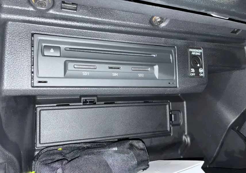 Gros plan sur le lecteur multimédia avec emplacements SD et SIM dans la boîte à gants d'un Audi Q2 noir 2023.