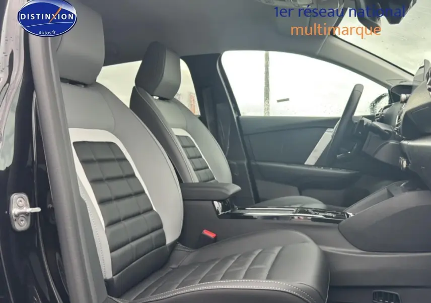 Intérieur de la Citroën C4 1.2 hybride 2025, vue côté gauche sur sièges cuir bicolores noir et gris avec accoudoirs.