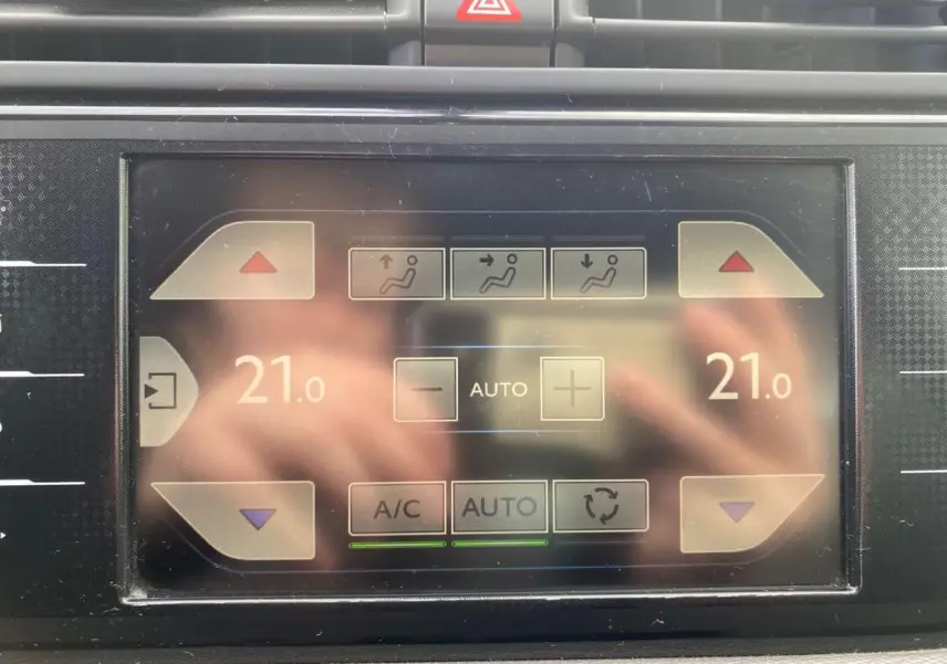 Écran tactile de la climatisation automatique bizone du Citroën Grand C4 Picasso blanc, vue rapprochée du tableau de bord.