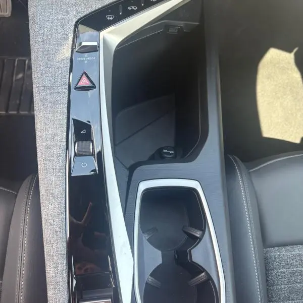Vue plongeante sur la console centrale du Peugeot 3008 Hybrid 136 e-DCS6 Allure 2025, avec finitions gris clair et commandes tactiles.