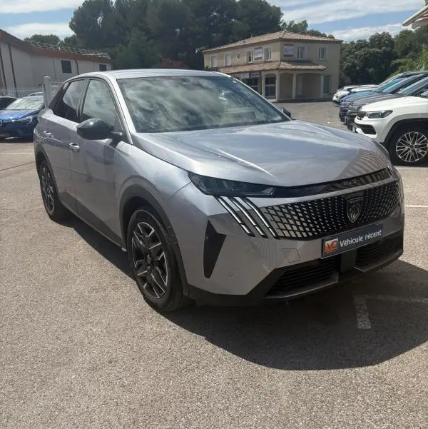 Peugeot 3008 Hybrid gris clair vue 3/4 avant droit, avec calandre distinctive et phares LED verticaux.