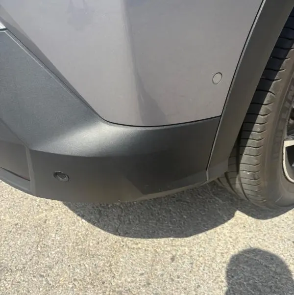 Détail du pare-chocs arrière droit gris clair du Peugeot 3008 Hybrid 136 e-DCS6 Allure 2025 avec capteurs de stationnement.