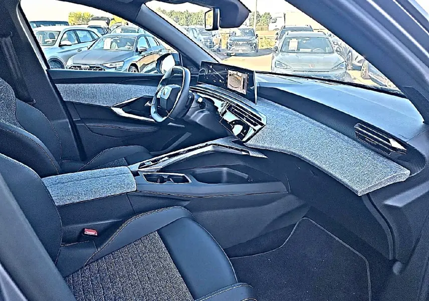 Vue intérieure côté conducteur du Peugeot 5008 Hybrid 145 allure e-dcs6 2025, tissus gris et tableau de bord moderne.