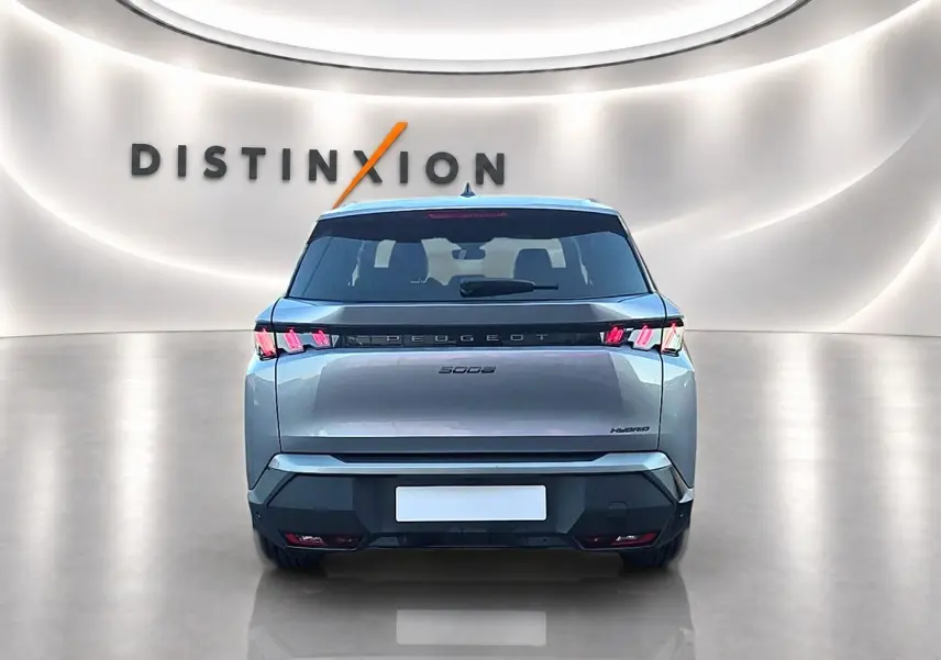 Vue arrière d'un Peugeot 5008 Hybrid 145 allure e-dcs6 gris artense dans un showroom lumineux avec logo Distinxion.