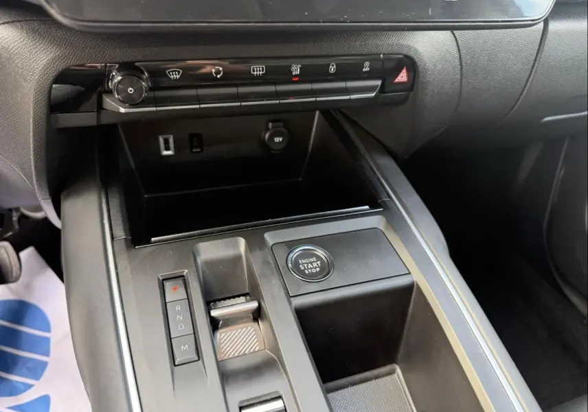 Gros plan sur la console centrale noire du Citroën C5 Aircross 2024, avec bouton start/stop et commandes de boîte auto.