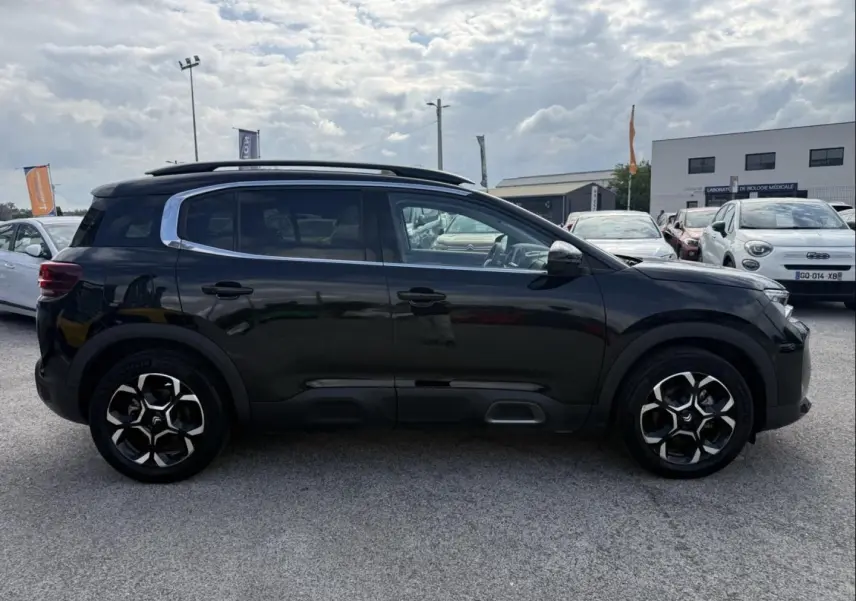 Profil côté droit du Citroën C5 Aircross 1.2 hybride 145 cv noir métal 2024 avec jantes spécifiques et toit ouvrant.