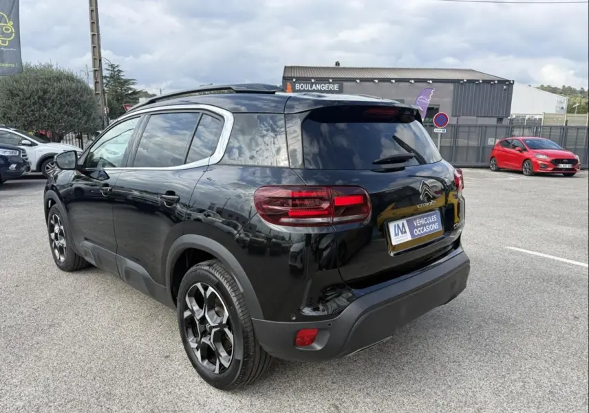 Vue 3/4 arrière droite du Citroën C5 Aircross 2024 noir métal avec jantes noires et vitres teintées.