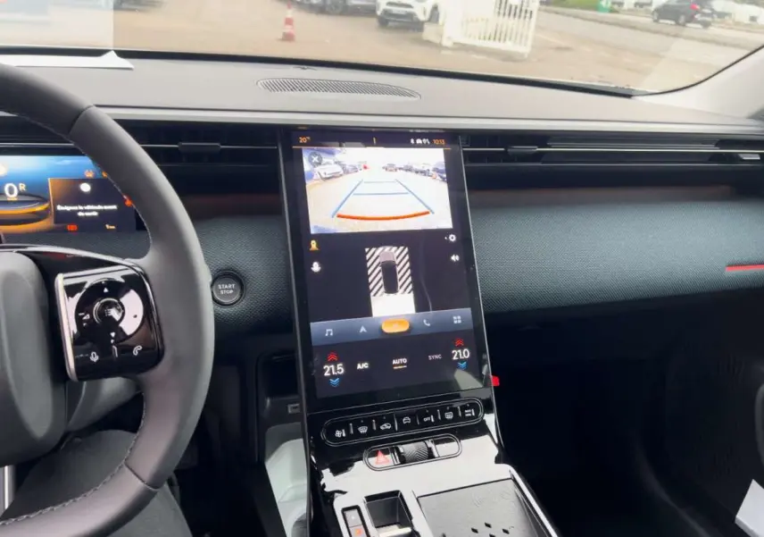 Vue intérieure centrée sur la console centrale tactile verticale du Citroën C5 Aircross Hybrid 2026 avec volant partiel.