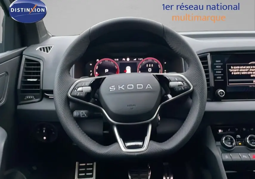 Vue frontale du volant SKODA KAROQ 1.5 TSI Sportline gris argent, avec tableau de bord numérique et commandes intégrées.