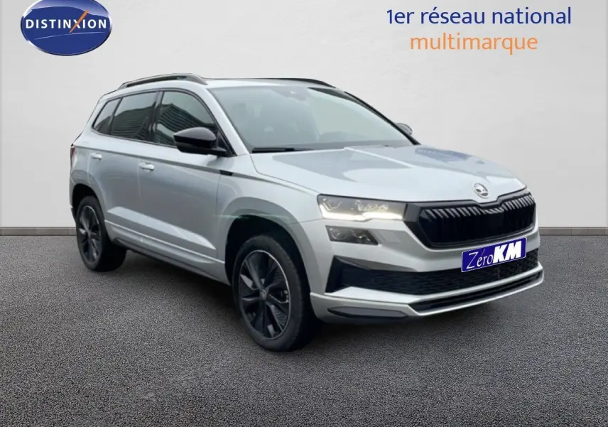 Vue 3/4 avant d'un Skoda Karoq gris argent métallisé avec jantes noires et calandre noire sportive.