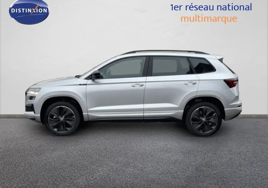 Vue de profil côté gauche d'un Skoda Karoq gris argent métallisé, version Sportline avec jantes noires.