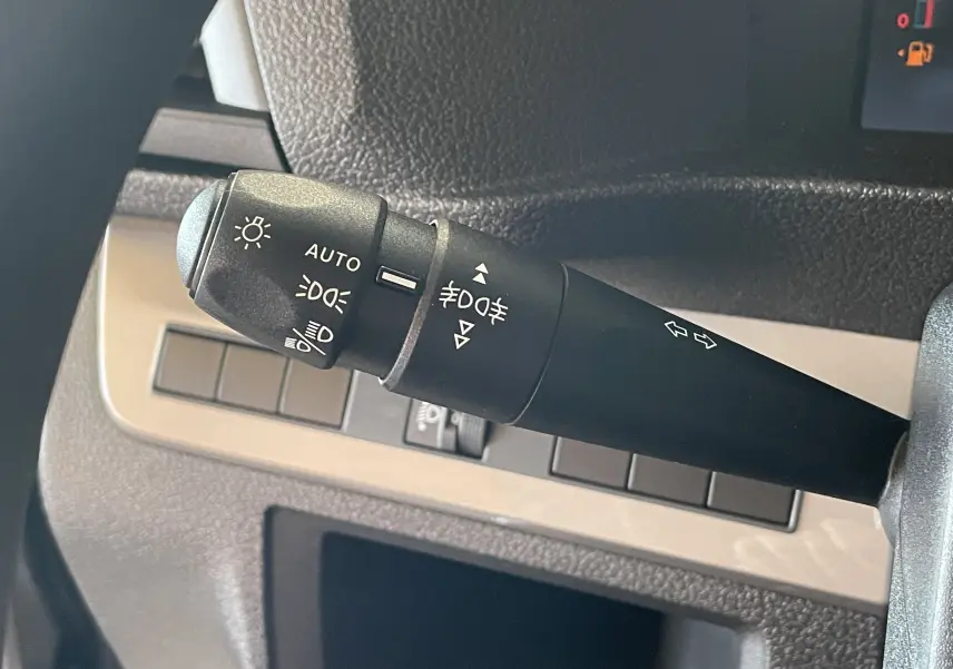 Gros plan sur la manette de commande des feux et clignotants du Citroën Jumpy Cabine Approfondie gris Artense, intérieur noir.