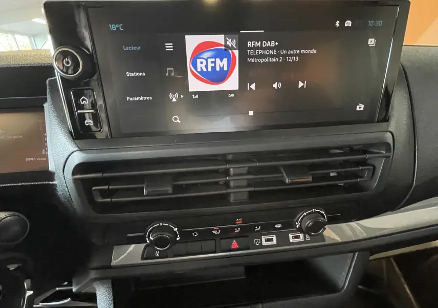 Vue rapprochée du tableau de bord noir du Citroën Jumpy cabine approfondie 2026 avec écran tactile et commandes climatisation.