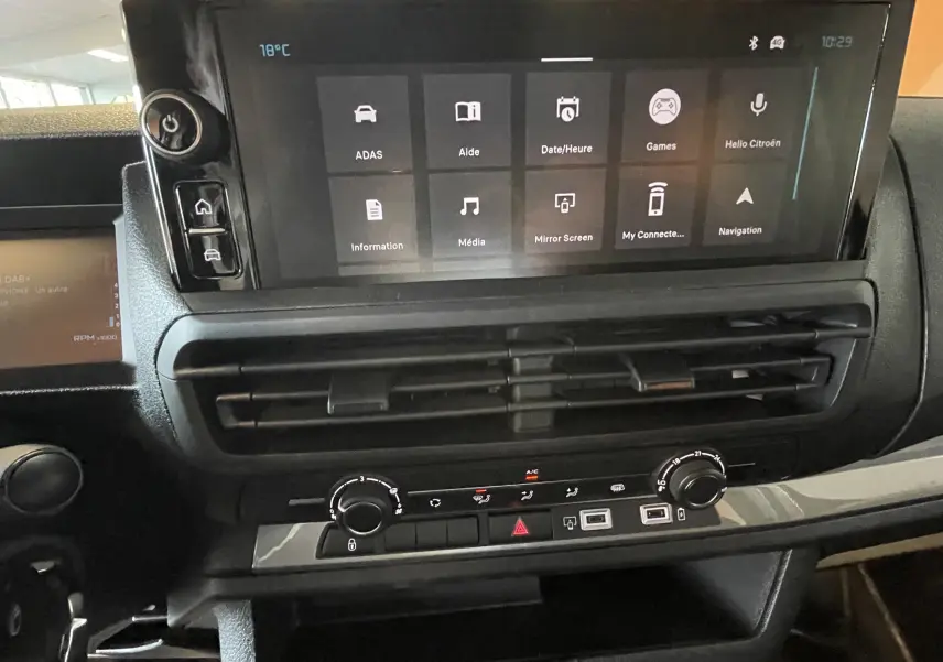 Vue rapprochée du tableau de bord noir du Citroën Jumpy cabine approfondie 2026 avec écran tactile et commandes de climatisation.