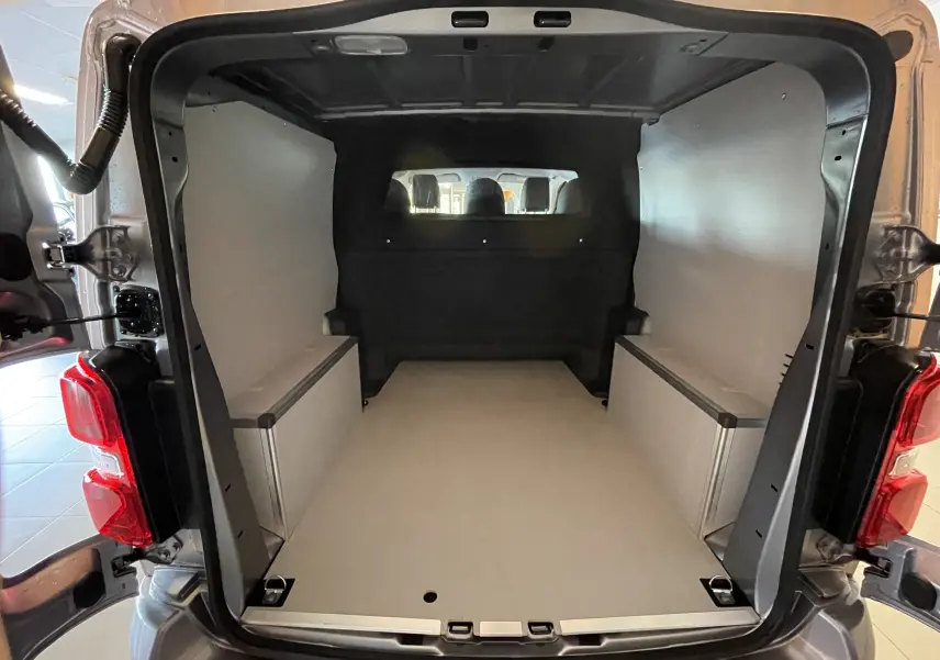 Vue arrière du Citroën Jumpy cabine approfondie gris Artense, montrant l'espace de chargement avec plancher et habillages bois.