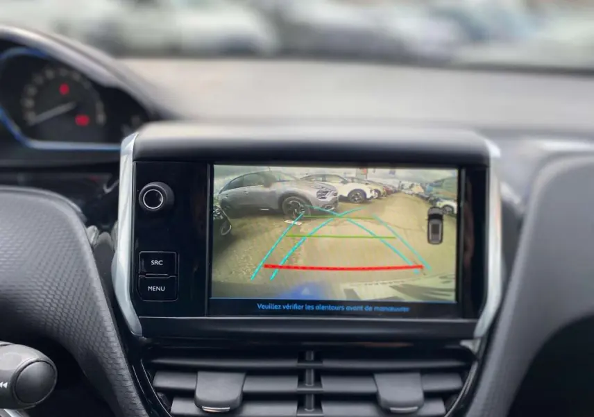 Écran central du Peugeot 2008 gris platinium montrant l’image de la caméra de recul avec lignes de guidage colorées.