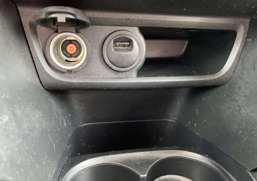 Détail de la prise allume-cigare et port USB dans la console centrale d’un Peugeot 2008 gris platinium.