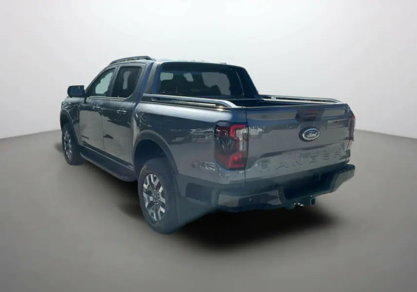 Ford Ranger PHEV gris carbone vu en 3/4 arrière droit, double cabine avec benne et barres de toit visibles.