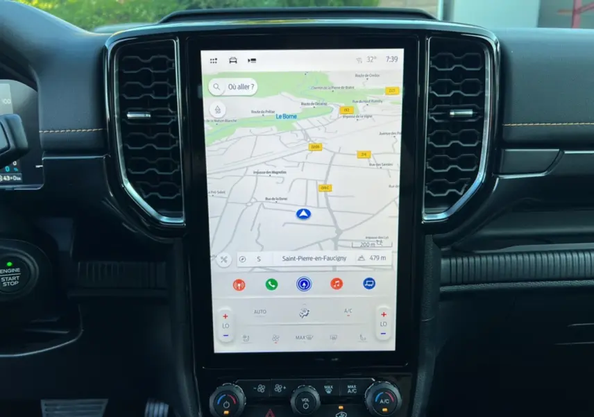 Vue rapprochée de la console centrale du Ford Ranger PHEV 2025 avec écran tactile GPS et commandes climatisation.