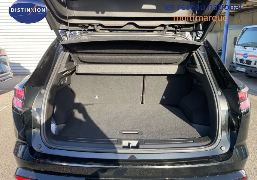 Coffre ouvert vu de l'arrière d'un Renault Austral noir étoile métal, montrant un espace de chargement spacieux et propre.