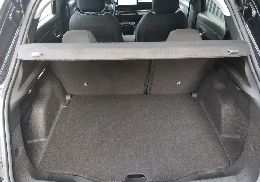 Coffre ouvert d'une FIAT 600 noire, vue de l'arrière montrant l'espace de chargement et les sièges avant.