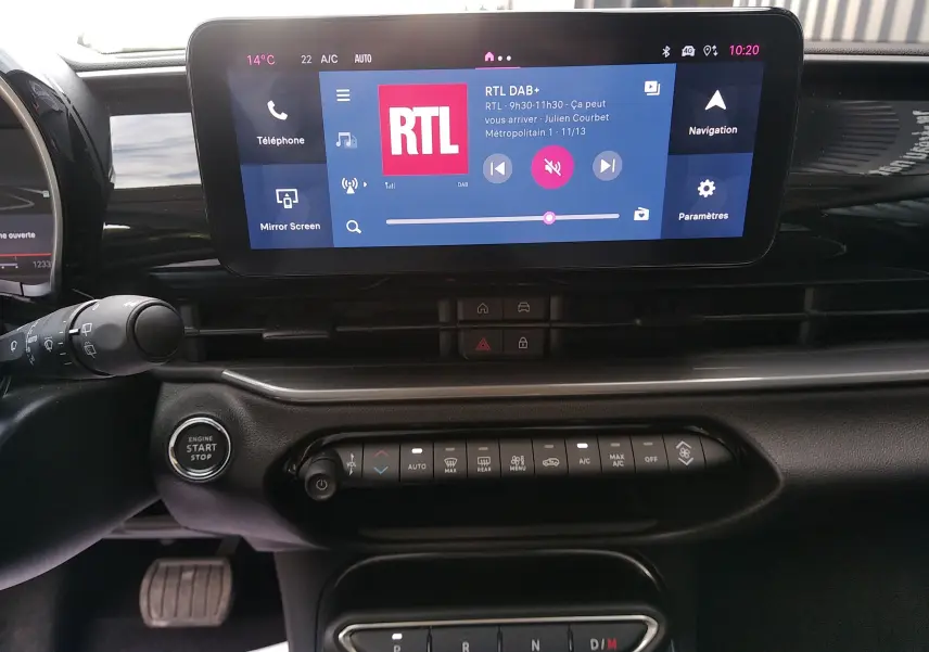 Vue rapprochée de l'intérieur du Fiat 600 noir 2025, montrant l'écran tactile central avec interface radio RTL et commandes climatisation.