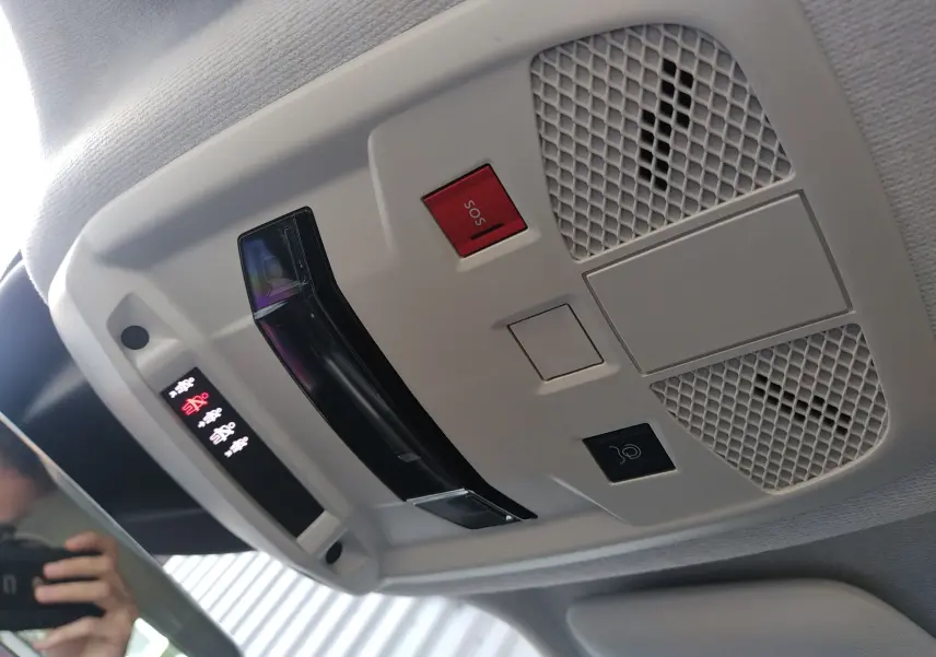 Vue en gros plan du plafonnier intérieur gris clair de la FIAT 600 noir, avec bouton SOS rouge et éclairage LED.