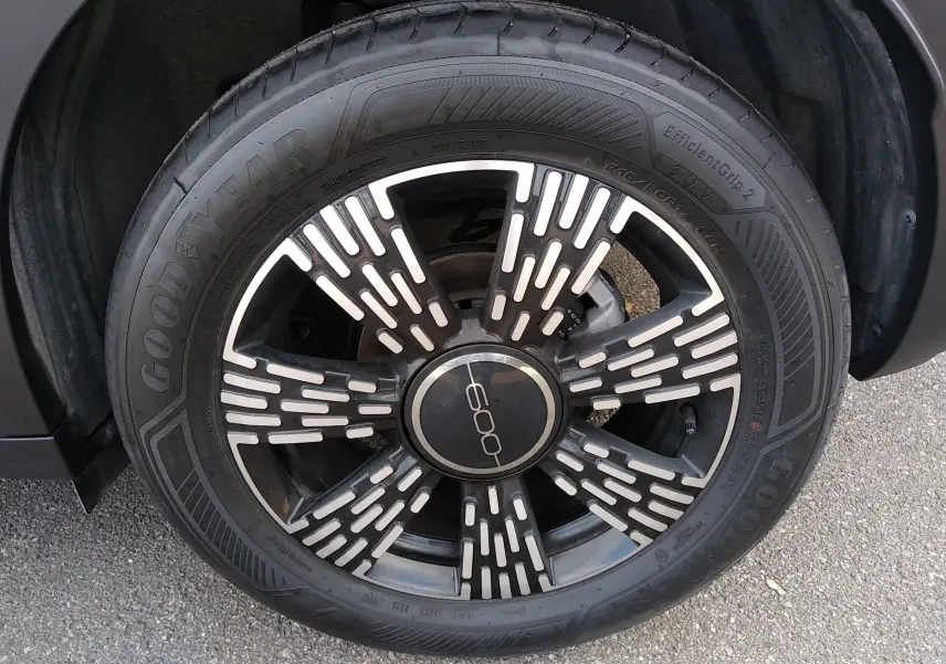 Gros plan sur la roue avant droite noire d'une FIAT 600 2025 avec jante stylisée et logo central "600".