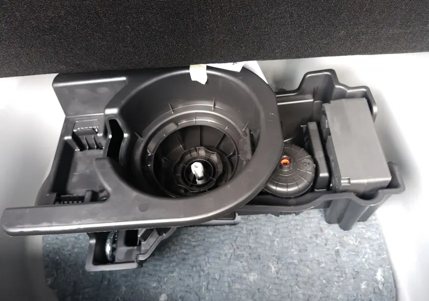 Gros plan sur le rangement noir d’accessoires dans le coffre du Fiat 600 hybride noir 2025.