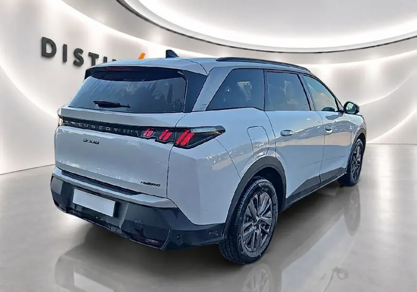 Vue 3/4 arrière droite d'un Peugeot 5008 blanc avec feux arrière LED et toit noir dans un showroom.