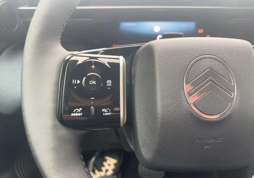 Gros plan sur le volant cuir multifonctions de la Citroën C5 Aircross Hybrid 2026 avec commandes au volant à gauche.
