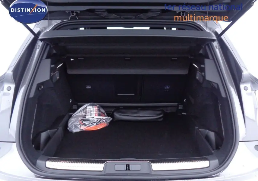 Coffre ouvert d'un DS7 Crossback gris platinium métal, montrant un espace de chargement propre avec accessoires rangés.